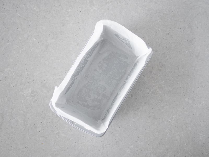 Keksówka firmy Wilton 23 cm wyłożona papierem do pieczenia.