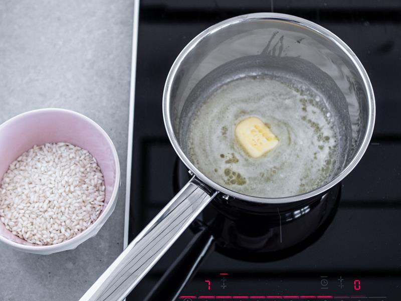 w rondelku rozpuszczone masło obok miseczka z ryżem
