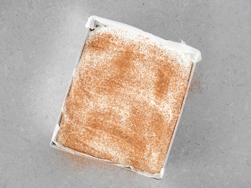 Ciasto dyniowe z kremem śmietankowym oprószone cynamonem.