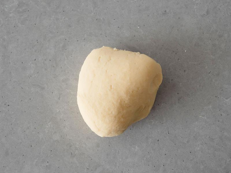 na blacie zagniecione w kulkę kruche ciasto