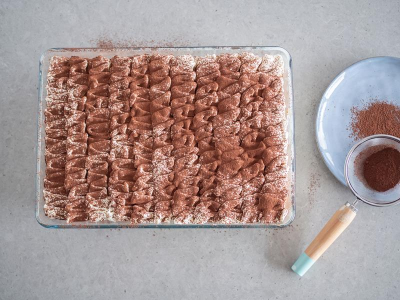 deser tiramisu bez jajek w dużej formie posypany przesianym przez sitko kakao ciemnym od dr. oetkera