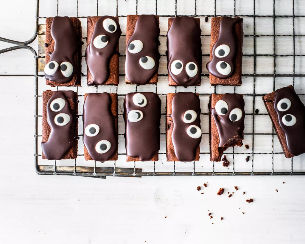 Brownie na halloween z polewą czekoladową pokrojone na kawałki i ozdobione oczkami - Wszystkiego Słodkiego