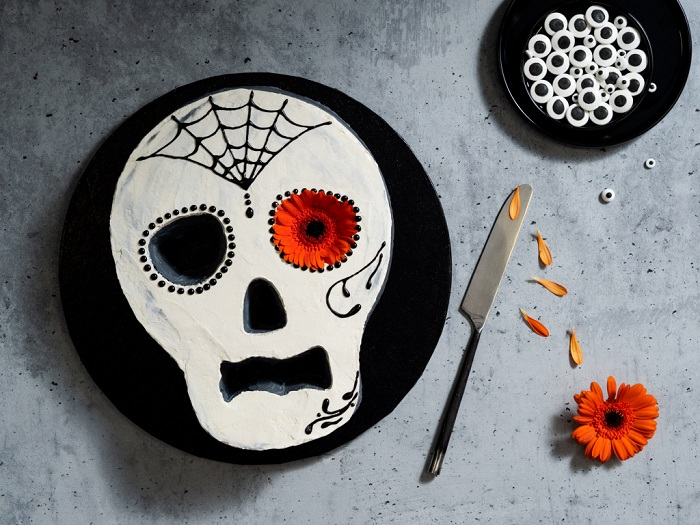 Ciasto na halloween w kształcie czaszki z kremem maślanym, udekorowane pisakami