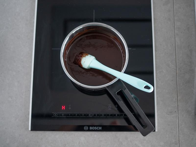 w rondelku na płycie kuchenki rozpuszczona z masłem czekolada