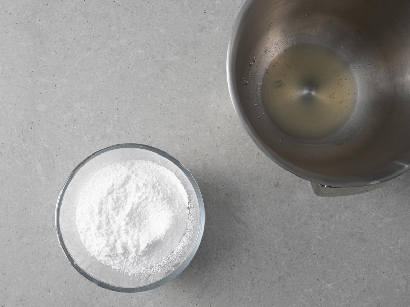 W misie malaksera aquafaba. Obok w miseczce cukier puder.