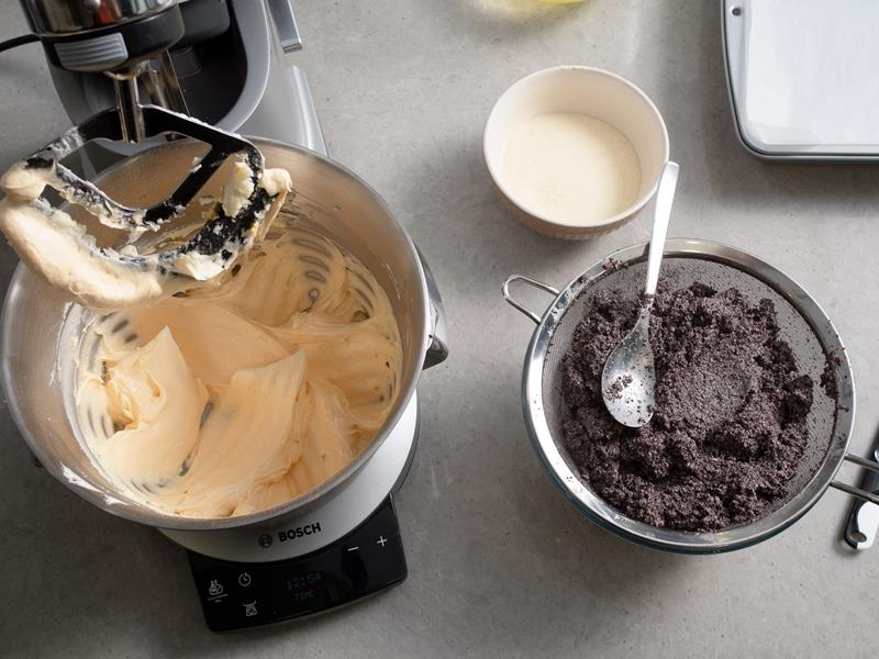 w misie robota kuchennego bosch utarte z cukrem i żółtkami masło, obok namoczony i odciśnięty z mleka mak na sicie oraz kasza manna w miseczce