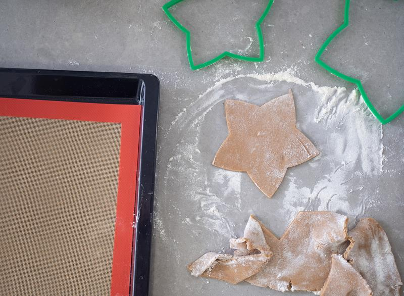 forma do pieczenia z matą sylikonową oraz ciasteczka gwiazdki z zielonymi foremkami