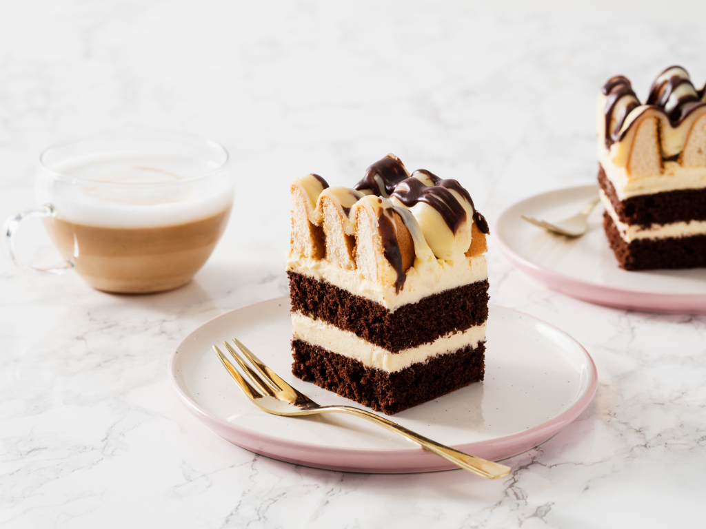 dwa kawałki ciasta góra lodowa podane z kawą - Wszystkiego Słodkiego