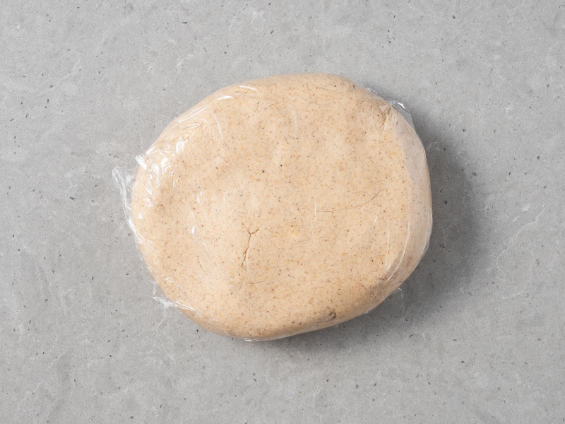 Zagniecione ciasto korzenne owinięte folią spożywczą.