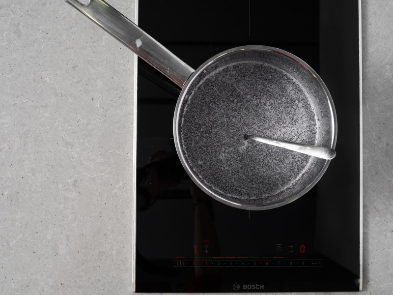 Mak gotowany z mlekiem w rondelku na palniku kuchenki