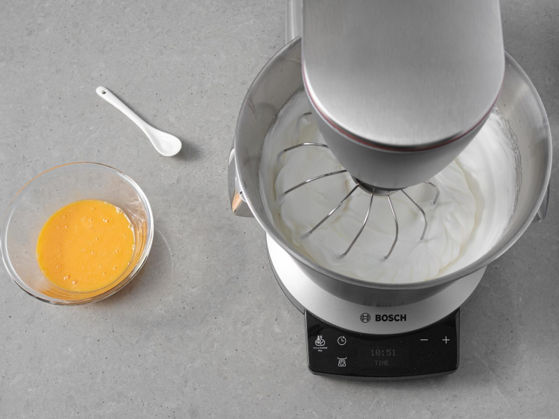 Ubite białka w misie miksera bosch. Obok żółtka w miseczce.