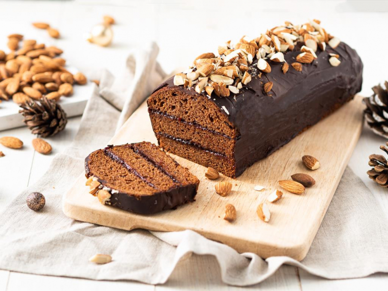 piernik wegański przełożony powidłami śliwkowymi, oblany czekoladą i posypany dużą ilością migdałów