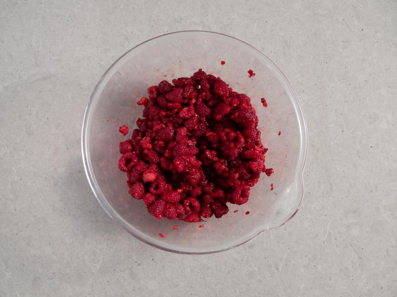 mrożone maliny w szklanej misce do galaretki z owocami