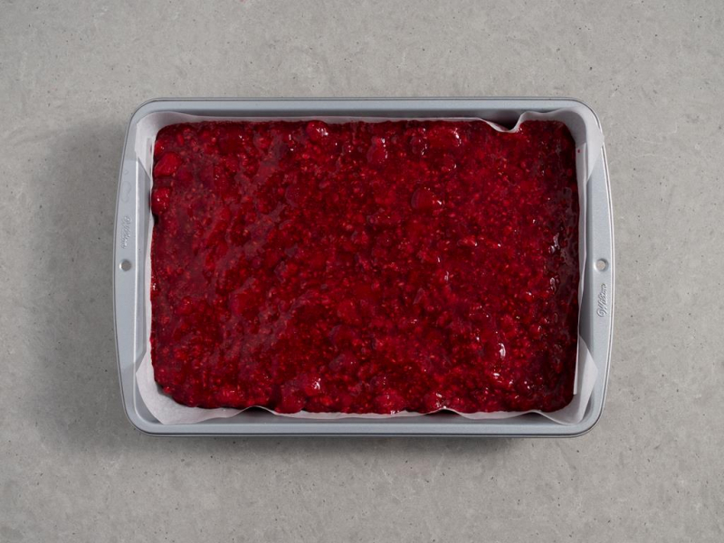 galaretka z malinami wylana na biszkopt w formie do pieczenia
