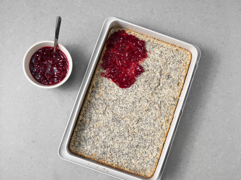 Konfitura żurawinowa rozłożona na makowym blacie.