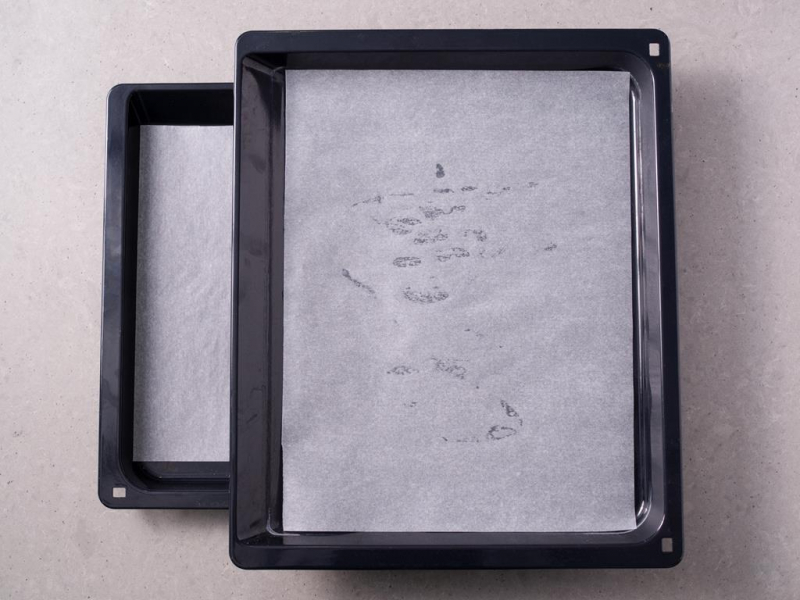 dwie blachy z wyposa偶enia piekarnika wy艂o偶one papierem do pieczenia