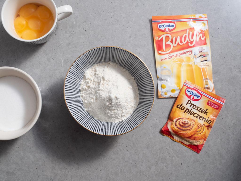 w miseczce mąka z proszkiem do pieczenia dr. oetker, obok budyń o smaku śmietanowym dr. oetkera