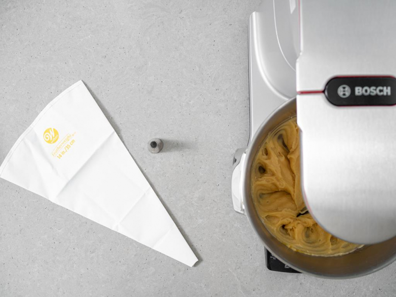 Ciasto w misie miksera. Obok rękaw cukierniczy firmy Wilton.