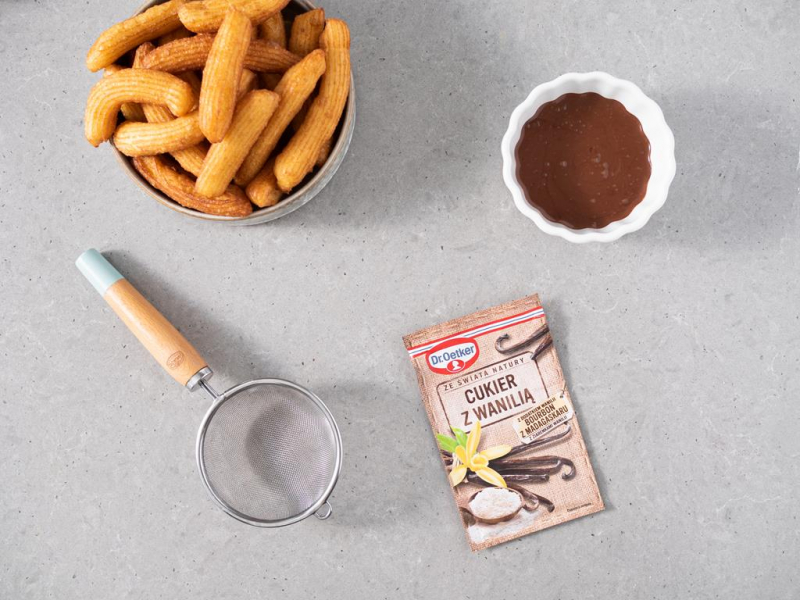 Gotowe churros z sosem czekoladowym i cukrem z wanilią Dr. Oetkera.