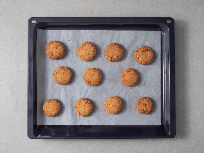 Upieczone ciasteczka a masłem orzechowym na blasze do pieczenia.
