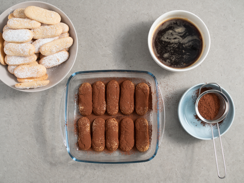 pierwsza warstwa biszkoptów oprószona kakao, kawa