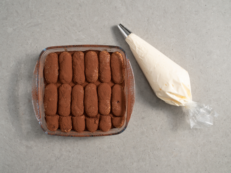 druga warstwa biszkoptów , krem w rękawie cukierniczym