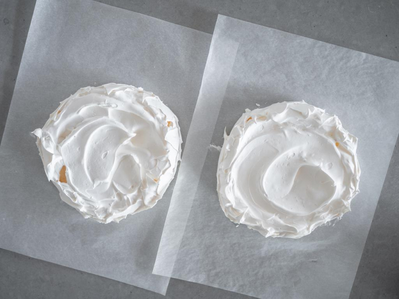 dwa upieczone blaty bezowe na papierze do pieczenia