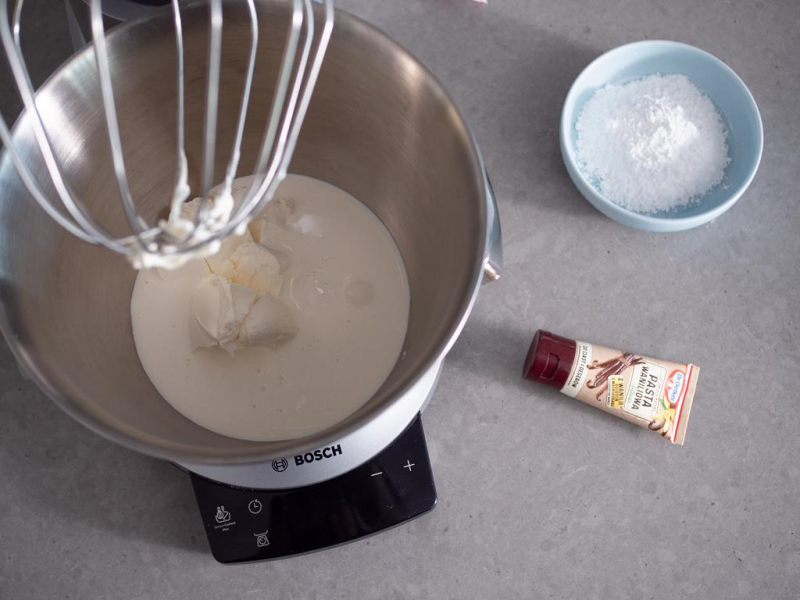 w misie robota Bosch śmietanka z mascarpone  obok pasta z wanilii dr.oetkera i cukier puder w miseczce