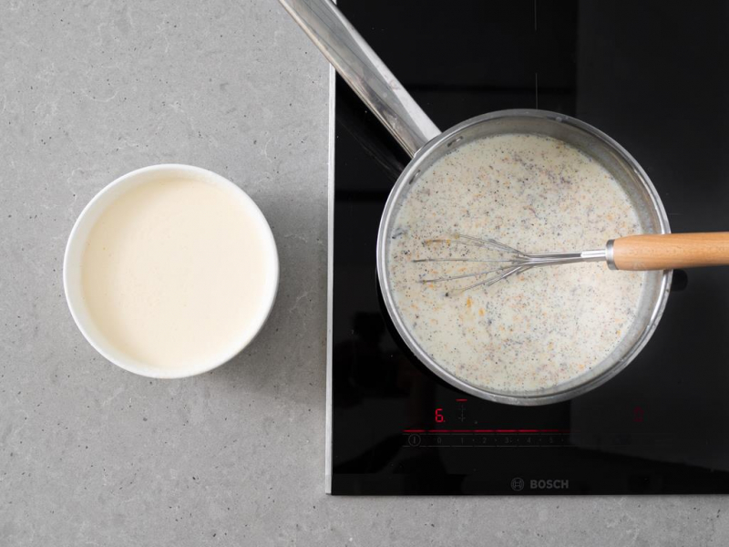 miseczka ze śmietaną z jajkami, rondelek z mlekiem, wanilią i skórkami cytrusów