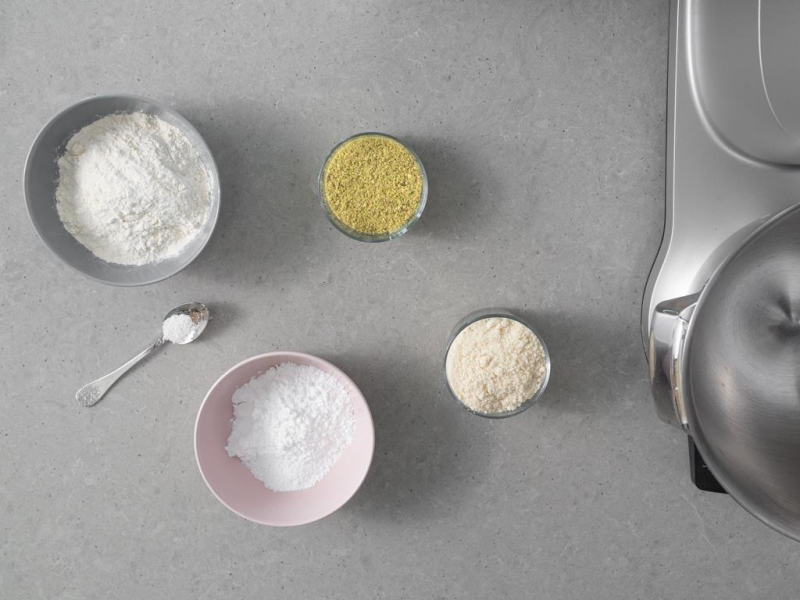 W miseczce mąka pistacjowa, mąka pszenna, cukier puder, szczypta soli oraz mąka migdałowa.
