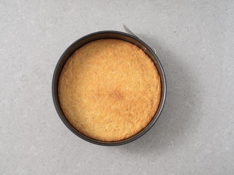 Upieczone ciasto pistacjowe w tortownicy.