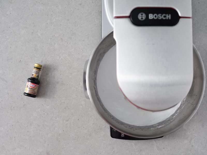 ubita beza włoska w misie miksera, obok ekstrakt z wanilii