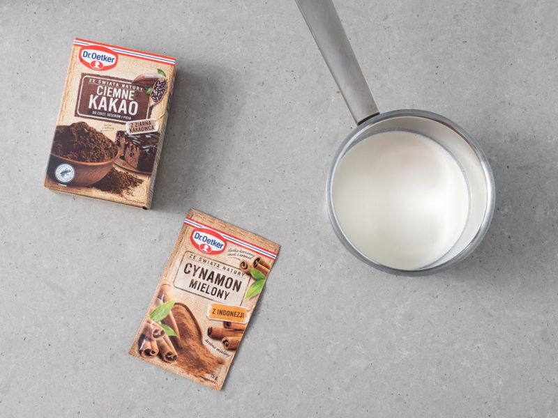 garnek ze śmietanką, obok kakao ciemne i cynamon