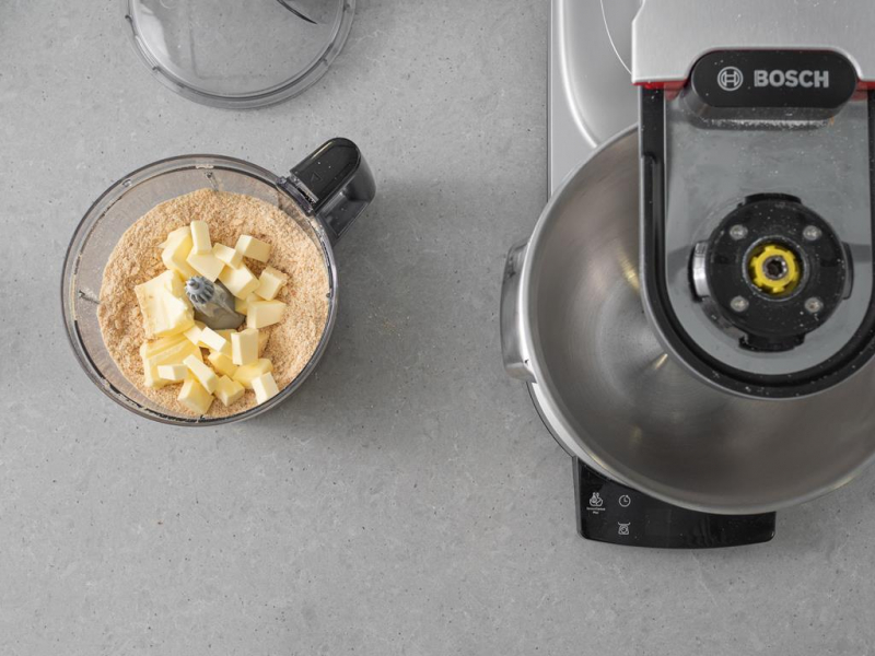 zmielone herbatniki i masło pokrojone w kostkę w malakserze