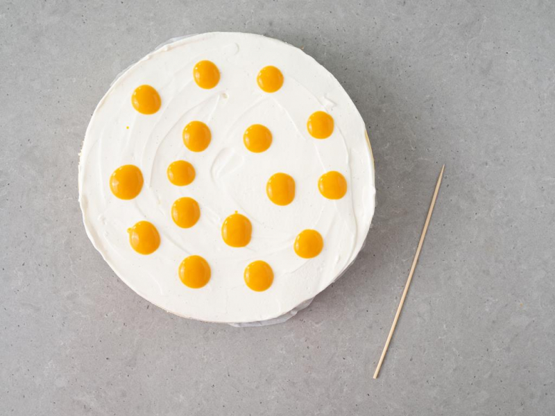 sernik z polewą, na wierzchu wyłożone kleksy z puree