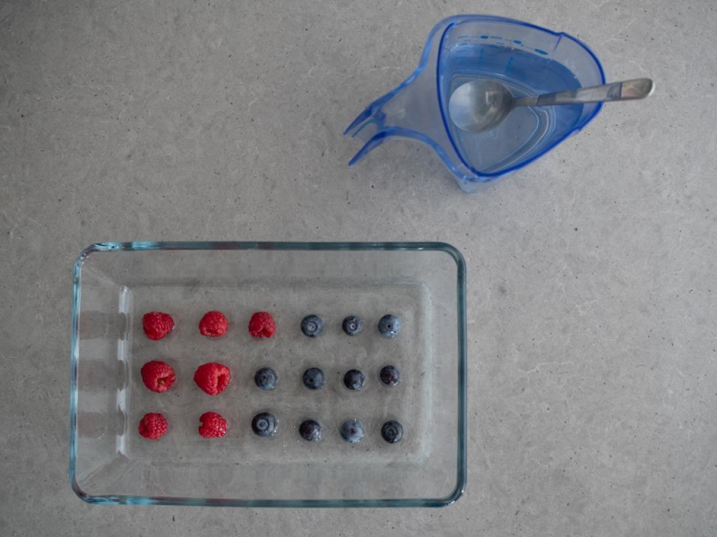 szklane naczynie z krystaliczną galaretką i ułożonymi w odstępach owocami