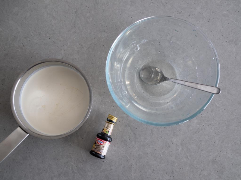 śmietanka z ekstraktem z wanilii w rondelku, miska z krystaliczną galaretką