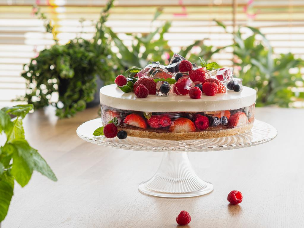 tort bez pieczenia z warstwami galaretki i owocami na szklanej paterze
