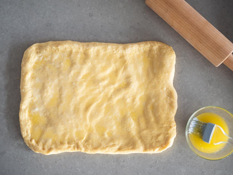 rozwałkowane ciasto drożdżowe posmarowane jajkiem