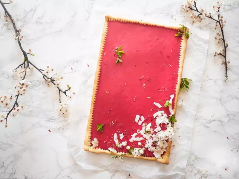 mazurek z różowym nadzieniem udekorowany pistacjami