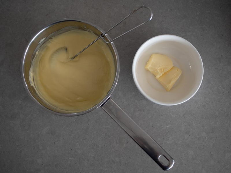 w rondelku budyń, obok miseczka z masłem