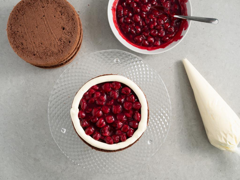 przekładanie biszkoptów kremem i frużeliną wiśniową