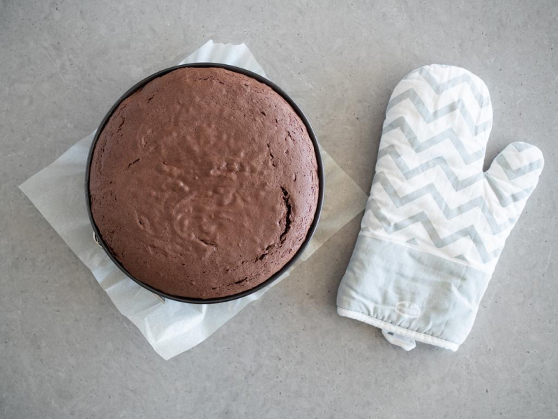 upieczony czekoladowy biszkopt obok rękawica dr.oetekra