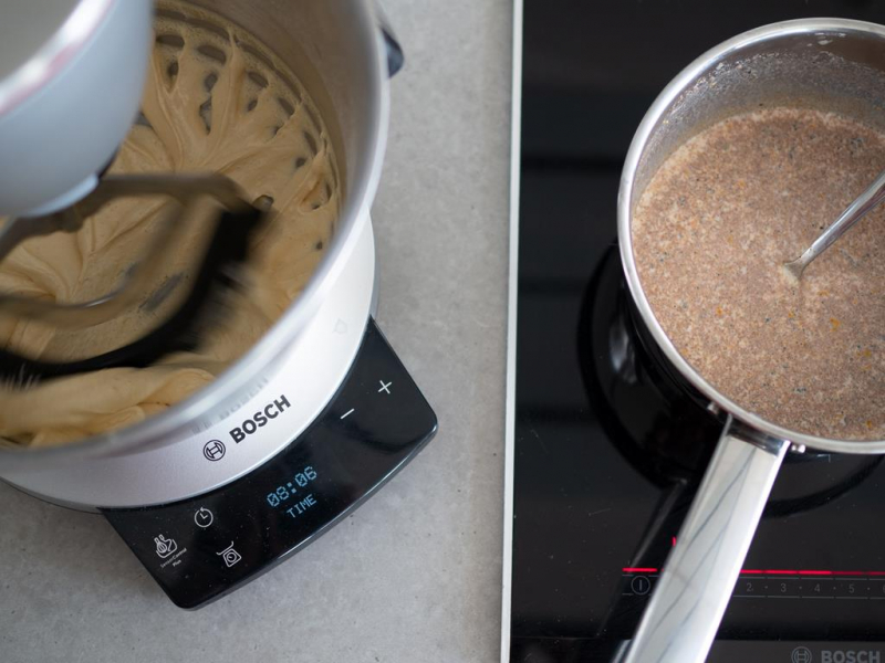 w robocie kuchennym bosch ucierane żółtka z cukrem obok rondelek na płycie