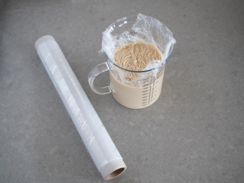 krem kataloński w szklanym dzbanku, obok folia spożywcza