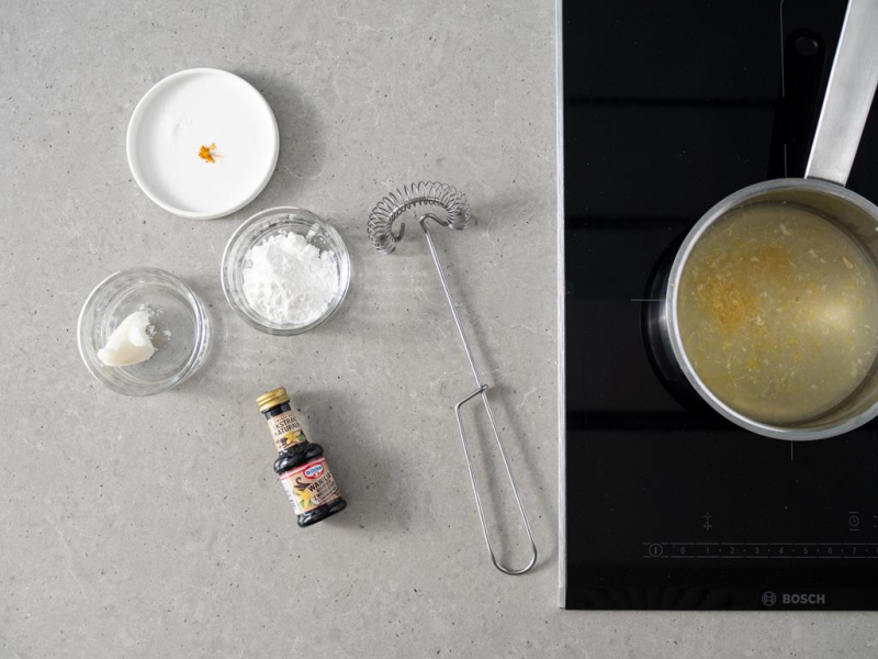 W garnku sok z cytryny z cukrem i skórką z cytryny. Obok skrobia, olej kokosowy, szczypta soli i kurkumy oraz ekstrakt z wanilii Dr. Oetkera