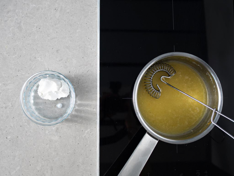 Podgrzana masa lemon curd w garnku. Obok mleczko kokosowe w miseczce.