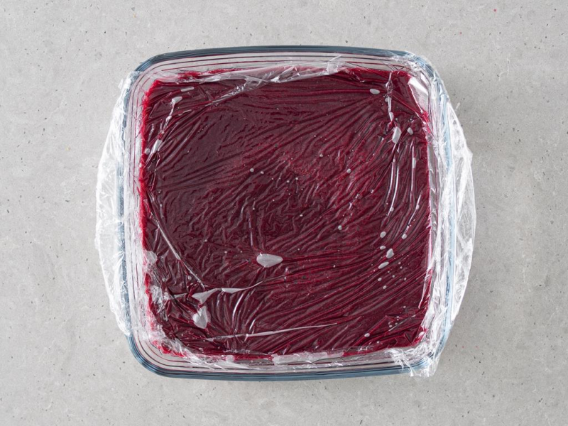 Wegańska owocowa frużelina w naczyniu,, przykryta folią.