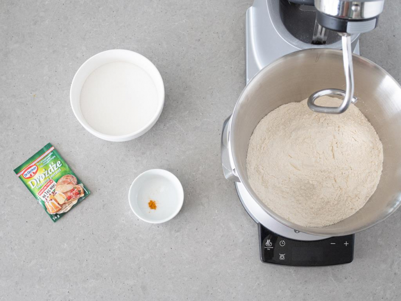 Mąka w robocie kuchennym. Obok cukier, drożdże suszone Dr. Oetkera, szczypta soli i kurkuma.