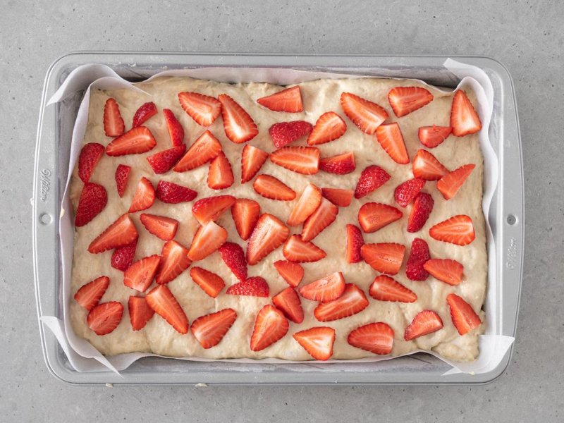 Wegańskie ciasto drożdżowe z ułożonymi truskawkami.